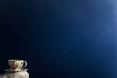 Bir fincan kahve ve kahve üzerinde mavi bir arka plan üzerinde beyaz kum taneleri