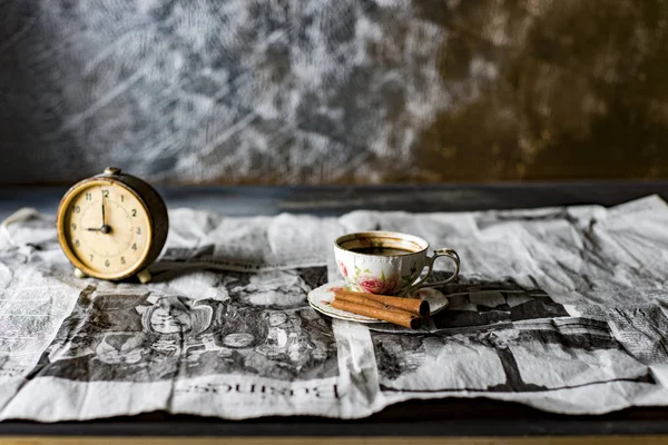 Stilleven met koffie, marshmallows, een wekker op een oude krant — Stockfoto