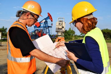 İki geodets anda bir petrol kuyusu üzerinde  