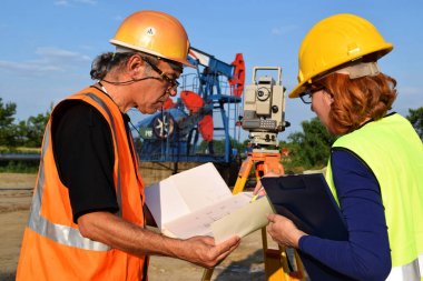 İki geodets anda bir petrol kuyusu üzerinde