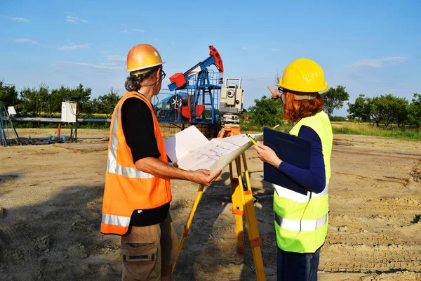 Two geodets at work on an oil well — Stock Photo, Image