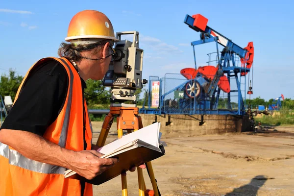 Um engenheiro geodésico de serviço no campo de petróleo — Fotografia de Stock