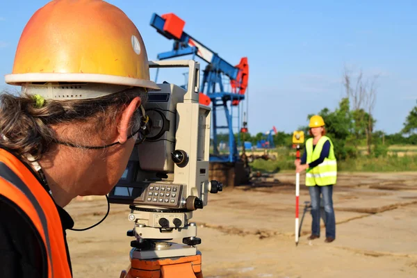 Two geodets at work on an oil well — Stock Photo, Image