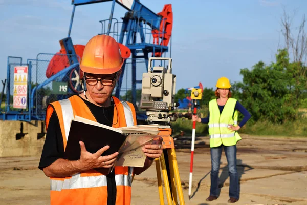 Dwa geodets w pracy na szybów naftowych — Zdjęcie stockowe