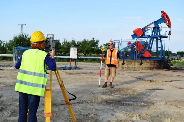 Zwei Geodäten bei der Arbeit an einer Ölquelle — Stockfoto