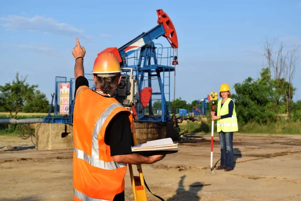 Dos geodets trabajando en un pozo de petróleo —  Fotos de Stock