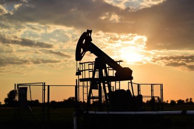 Günbatımı zamanı sırasında bir petrol pompa silüeti