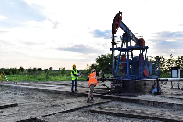İki petrol mühendisleri, bir Avrupa petrol kuyusu üzerinde çalışır   