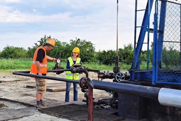 İki petrol mühendisleri, bir Avrupa petrol kuyusu üzerinde çalışır   