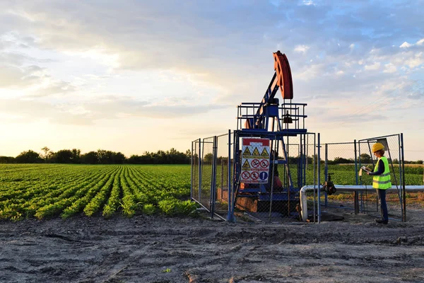 Une technicienne de l'industrie pétrolière au travail pendant le crépuscule — Photo