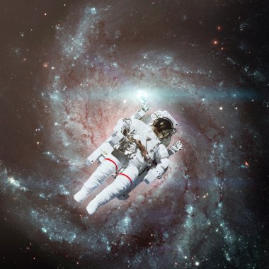 Astronot uzayda. Arka planda sarmal gökada.