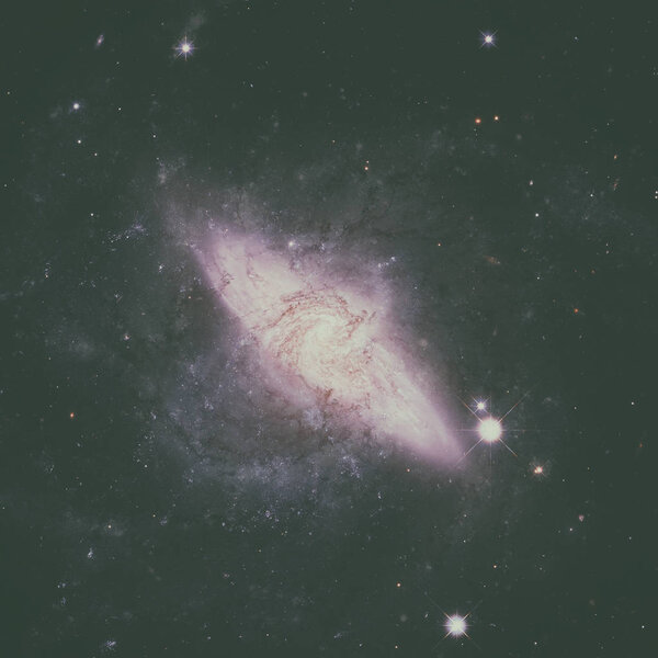 NGC 3314 is a pair of overlapping spiral galaxies between 117 and 140 million light-years away in the constellation Hydra. Elements of this image furnished by NASA.