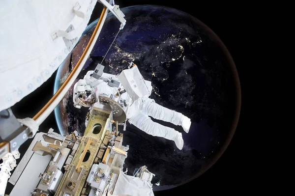 Астронавт плавает рядом с планетой Земля. Элементы этого изображения предоставлены НАСА — стоковое фото