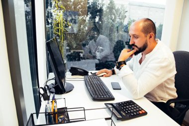 Kağıtları ve bilgisayarları oturan işadamı