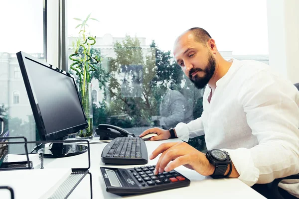 Empresário sentado atrás de papéis e computadores — Fotografia de Stock