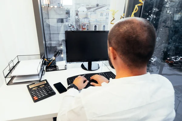 Empresário sentado atrás de papéis e computadores — Fotografia de Stock