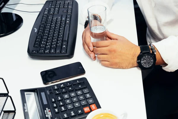 Empresário sentado atrás de papéis e computadores — Fotografia de Stock