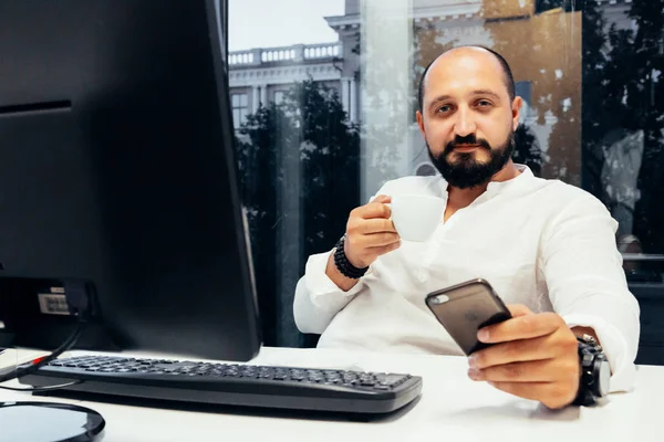 Empresário sentado atrás de papéis e computadores — Fotografia de Stock