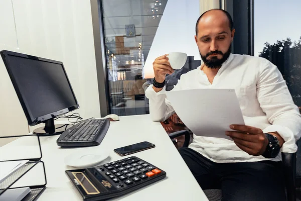 Empresário sentado atrás de papéis e computadores — Fotografia de Stock