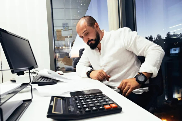 Empresário sentado atrás de papéis e computadores — Fotografia de Stock