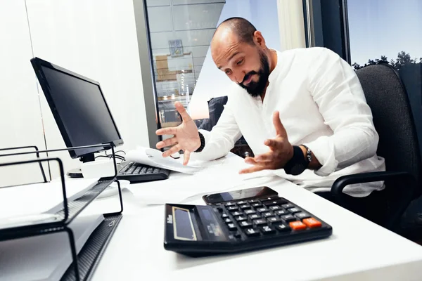 Empresário sentado atrás de papéis e computadores — Fotografia de Stock