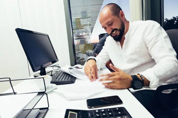 Empresário sentado atrás de papéis e computadores — Fotografia de Stock