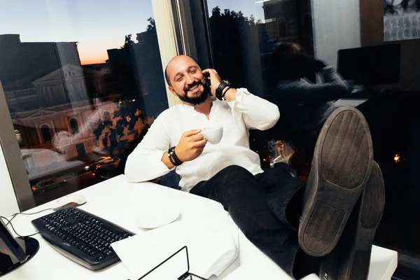 Empresário sentado atrás de papéis e computadores — Fotografia de Stock