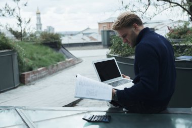 Çatıda çalışan yakışıklı genç işadamı