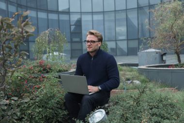 Çatıda çalışan yakışıklı genç işadamı