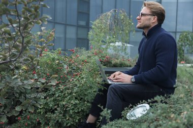 Çatıda çalışan yakışıklı genç işadamı