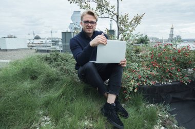 Çatıda çalışan yakışıklı genç işadamı