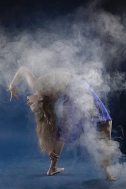 Zıplayan kız ve mavi arka planda güzel bir poz.