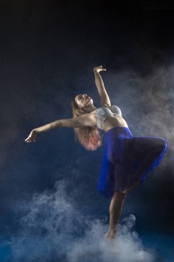 Zıplayan kız ve mavi arka planda güzel bir poz.