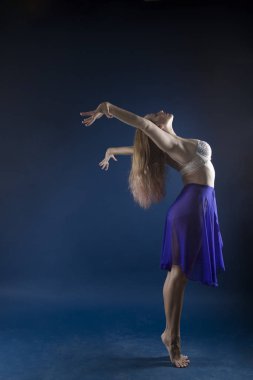 Zıplayan kız ve mavi arka planda güzel bir poz.