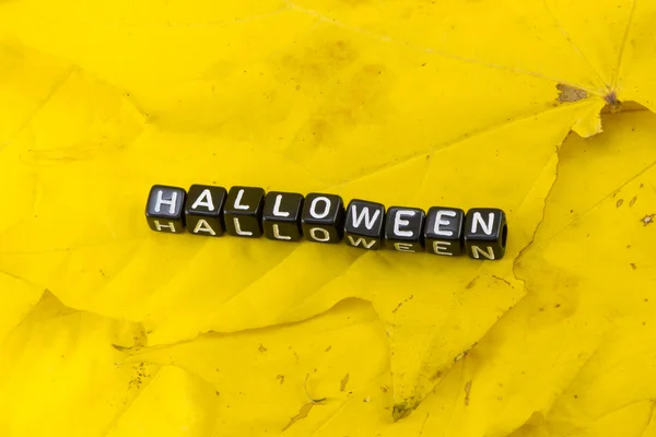 Yaprakların bir arka plan üzerinde kelime Halloween — Stok fotoğraf