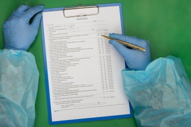 Masanın üzerine doktor hasta geçmişi doldurur
