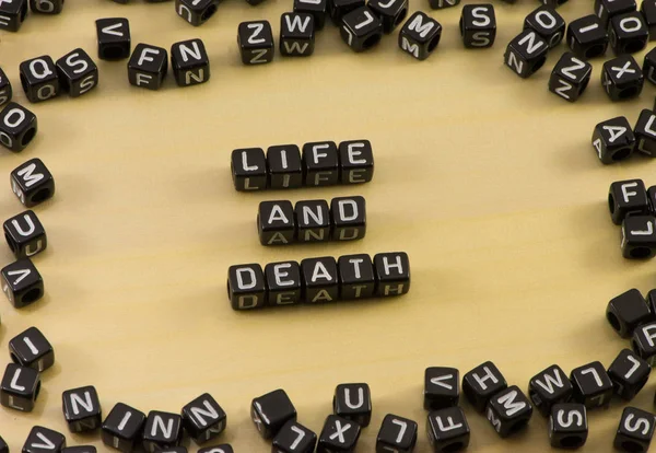 Слово "жизнь и смерть" на деревянном фоне — стоковое фото