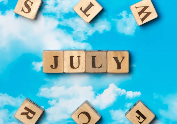 Ordet juli på sky bakgrunden — Stockfoto