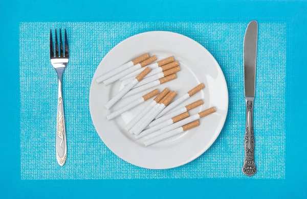 Cigarrillos en un plato — Foto de Stock