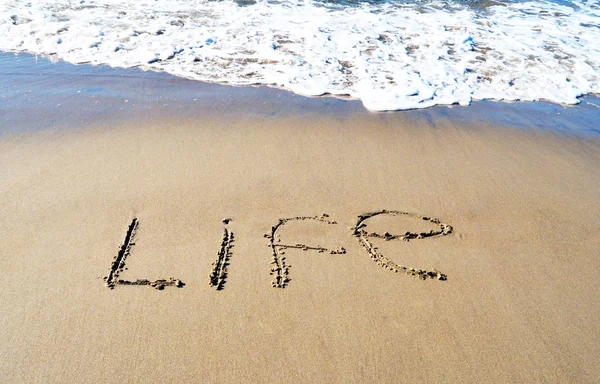 Het woord leven op het strand-achtergrond — Stockfoto