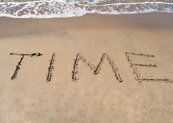 Das Wort Zeit auf dem Strandhintergrund Stockbild