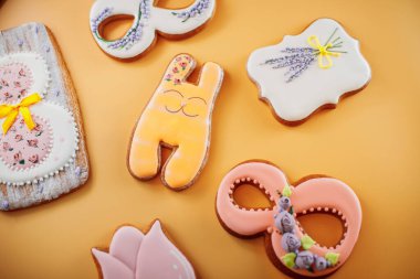 Sarı arka planda farklı şekillerde zencefilli kurabiyeler.