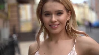 Şeftali rengi elbiseli bir sarışın ve sokakta yürüyen ayakkabılar.