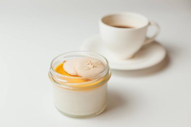 Mangolu puding, beyaz arka planda kurabiye ve kahve.