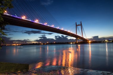 Alacakaranlık zaman Hooghly Nehri Vidyasagar köprüde (tertibat). Hindistan'da en uzun kablo kaldı Köprüsü bu. Köprü Kolkata Howrah İlçe Batı Bengal ile bağlanır..