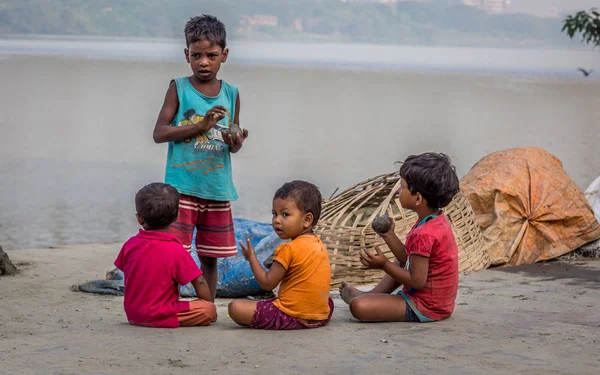 Crianças de rua brincam com barro da margem do rio Ganges perto da ponte Howrah — Fotografia de Stock