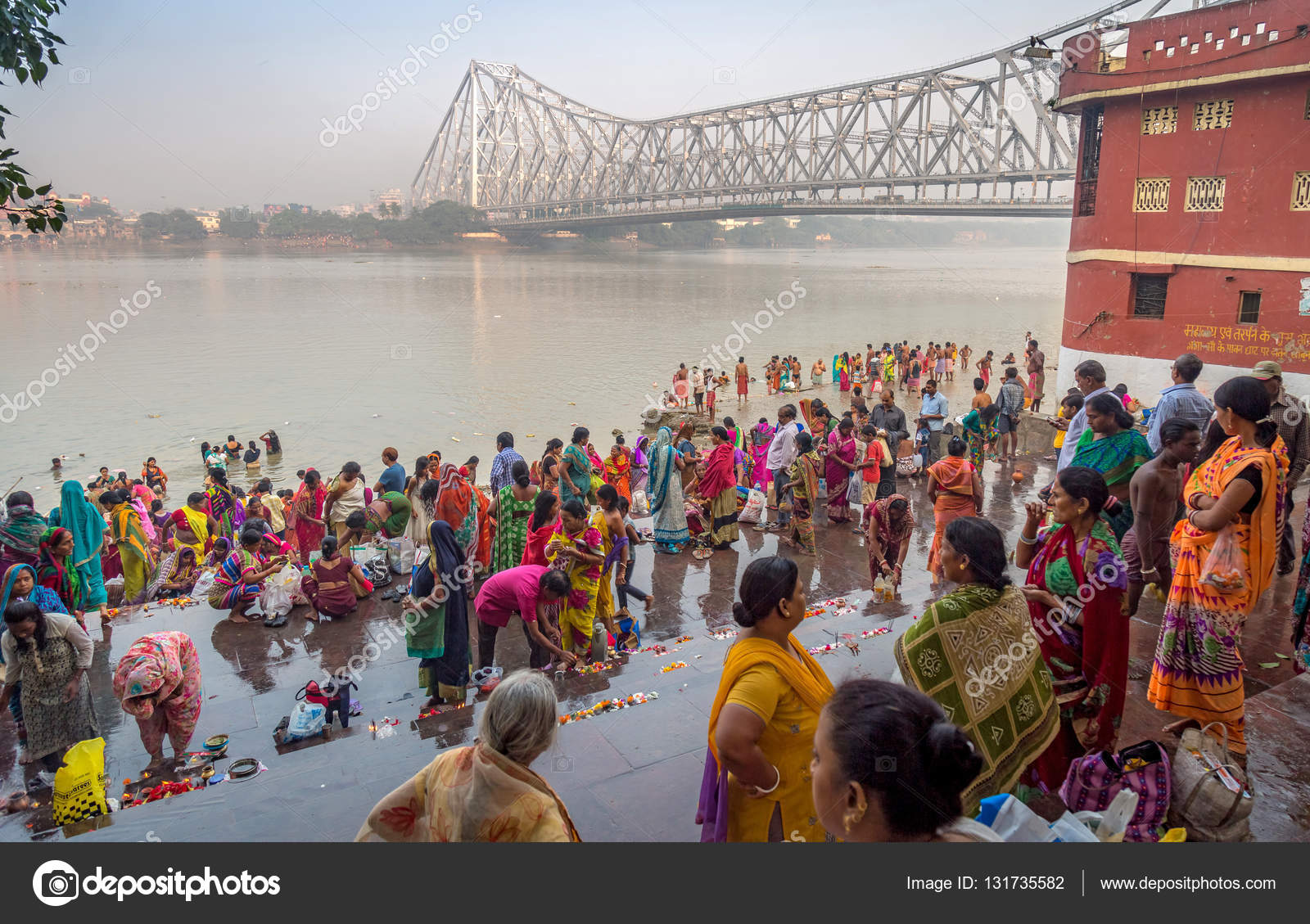 People throng the Ganges river bank near Howrah bridge for a holy