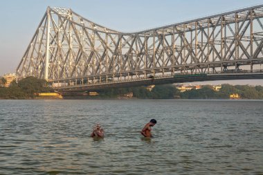 Kolkata Howrah yakınlarında Ganj Nehri'nde banyo insanlar köprü.