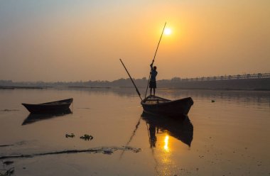 Siluet tekne ile gün batımında oarsman nehrinde Damodar Batı Bengal, Hindistan.