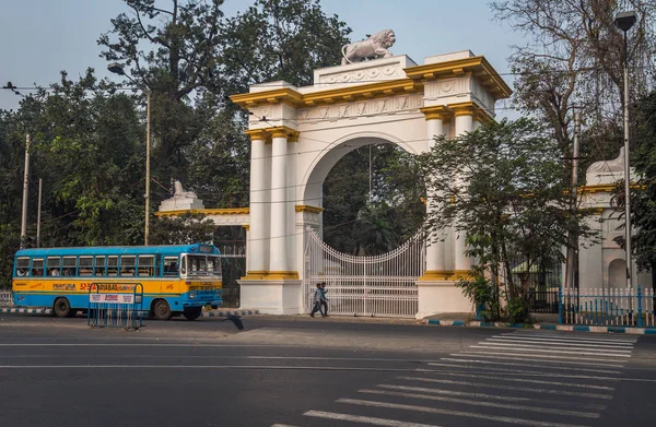 Un autobús de transporte público cruza la entrada de la casa del gobernador de arquitectura gótica cerca de la zona de Dharmatala Chowringhee . — Foto de Stock